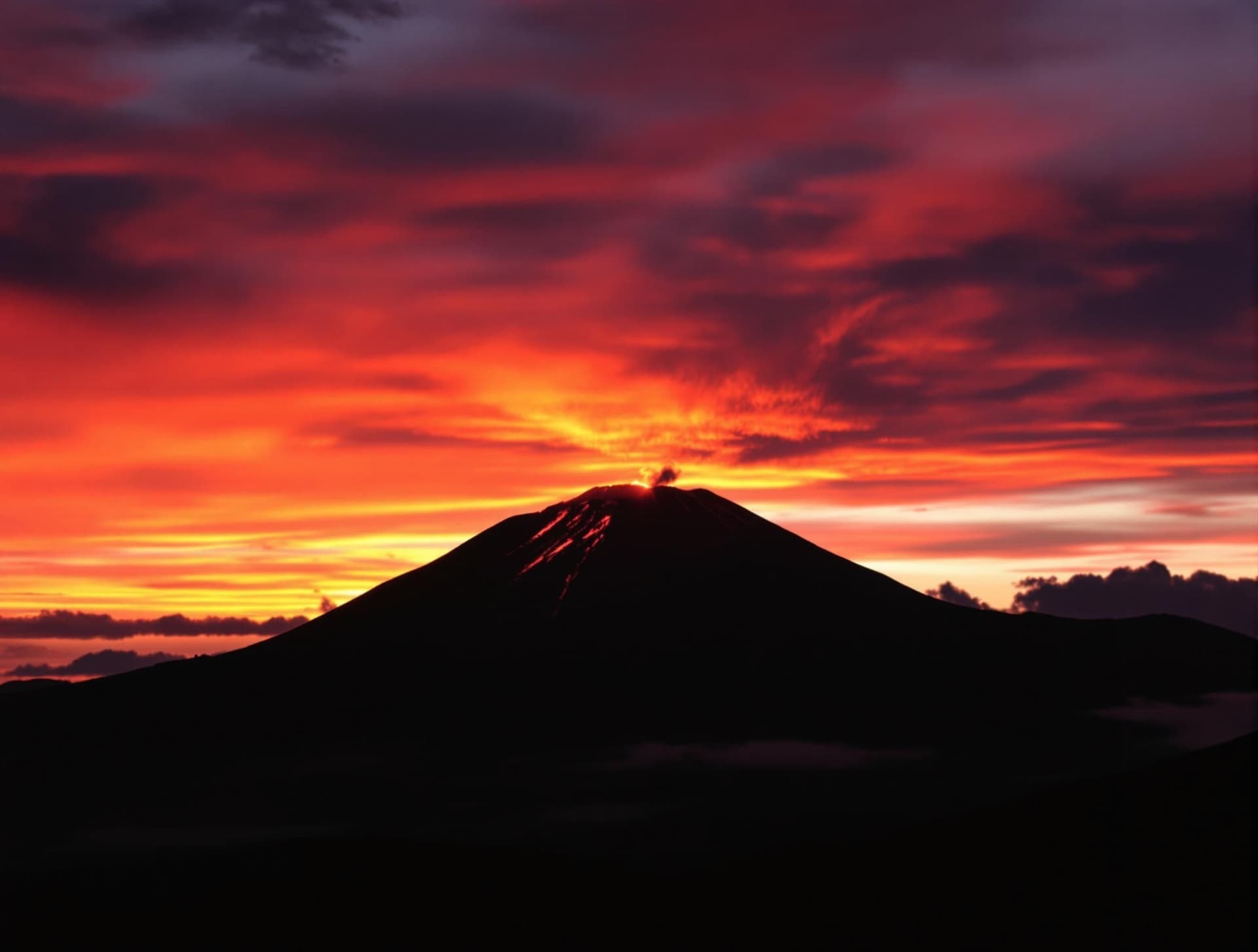 Etna-vulkanen vid solnedgången, med dramatiskt orange och rött ljus som faller över det vulkaniska landskapet
